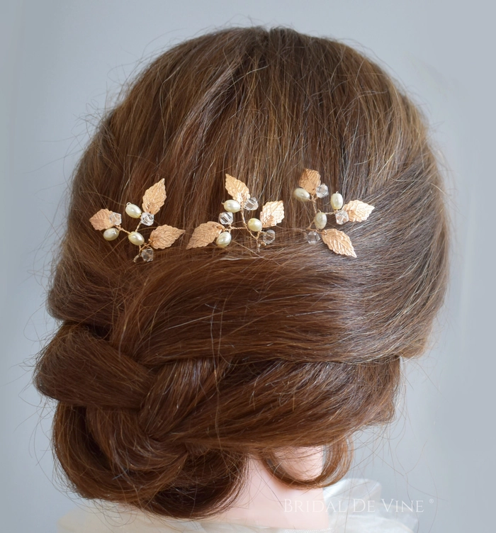 A hairstyle featuring autumn leaf hair pins arranged in a loose braid for a festive holiday look