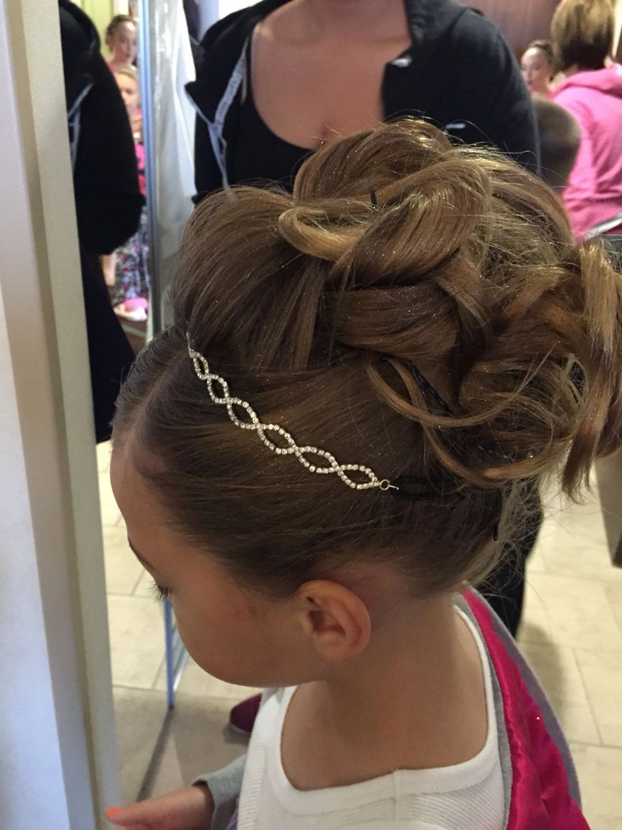 Child with a comfortable updo hairstyle wearing a festive holiday pageant outfit