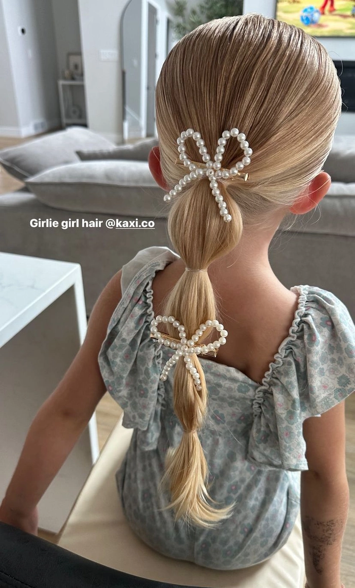 Toddler with an easy holiday hairstyle featuring cute braids and tiny festive bows