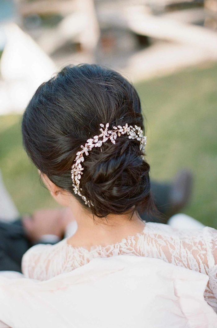 Winter wedding chignon with pearl pins and delicate snowflake accents