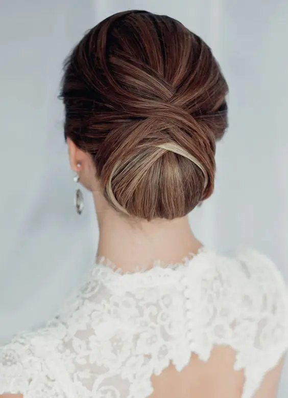 Elegant chignon hairstyle for a winter wedding with delicate accessories