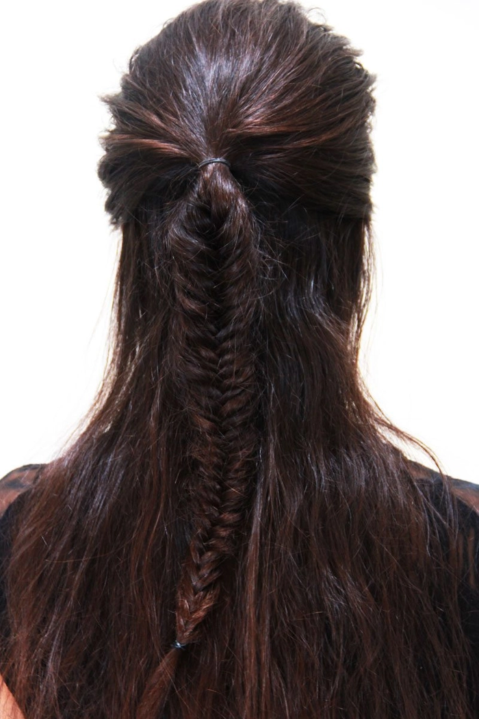 Casual fishtail braid hairstyle perfect for a vacation getaway Relaxed fishtail braid on a woman enjoying a sunny holiday beach