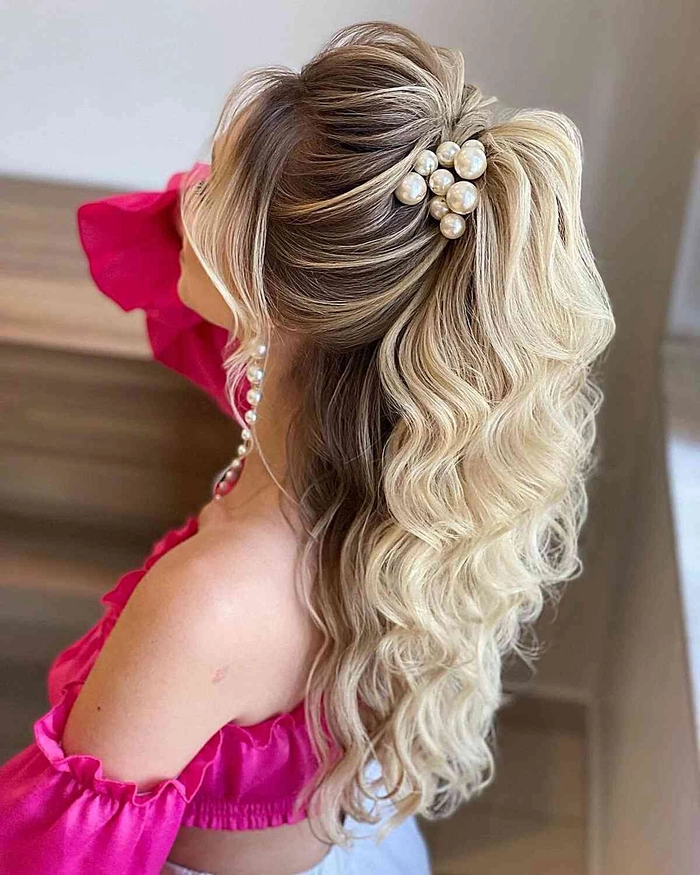Elegant half-up hairstyle with subtle waves and accessories for a holiday theater outing