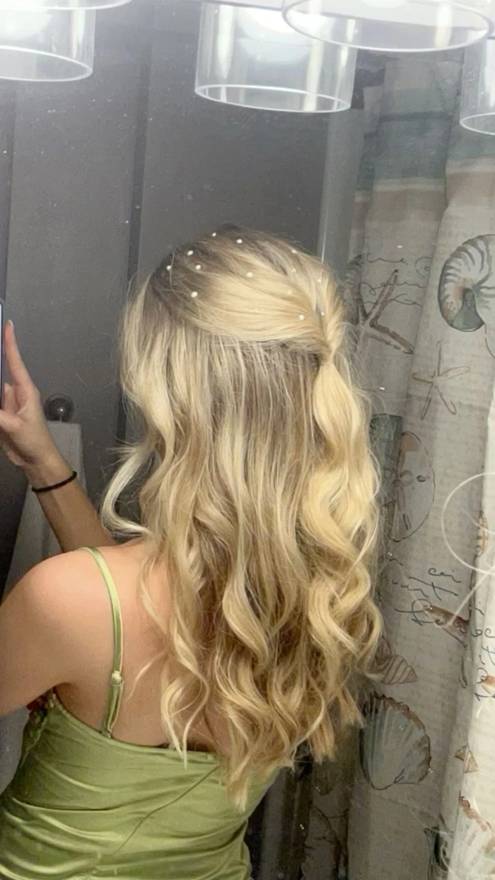 Elegant half up hairstyle for a holiday theater outing with soft waves and delicate accessories