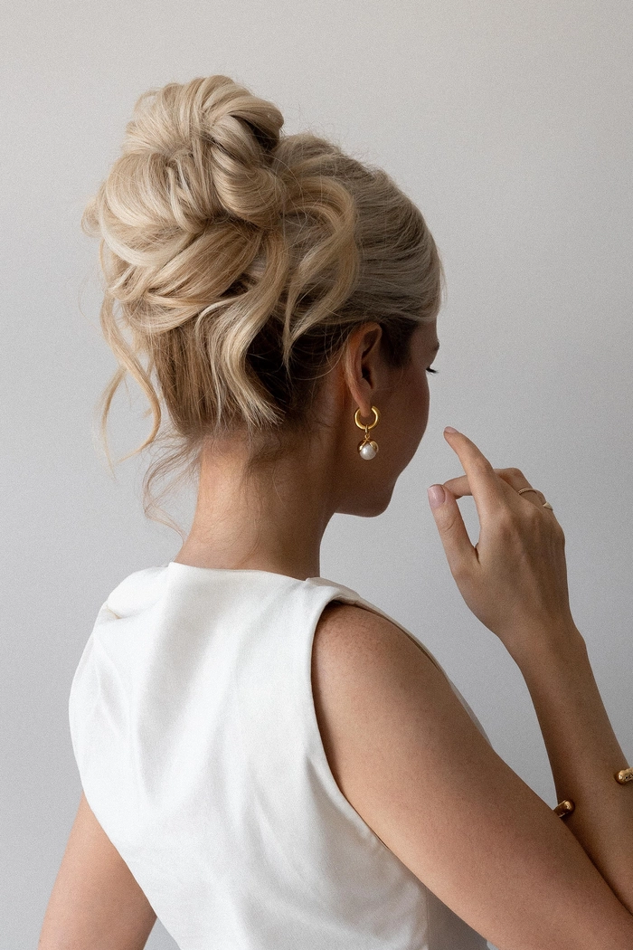 Elegant holiday hairstyle for wedding guests with braided details and festive floral accents Holiday wedding guest hair inspiration featuring a chic half-up style with glittering ornaments