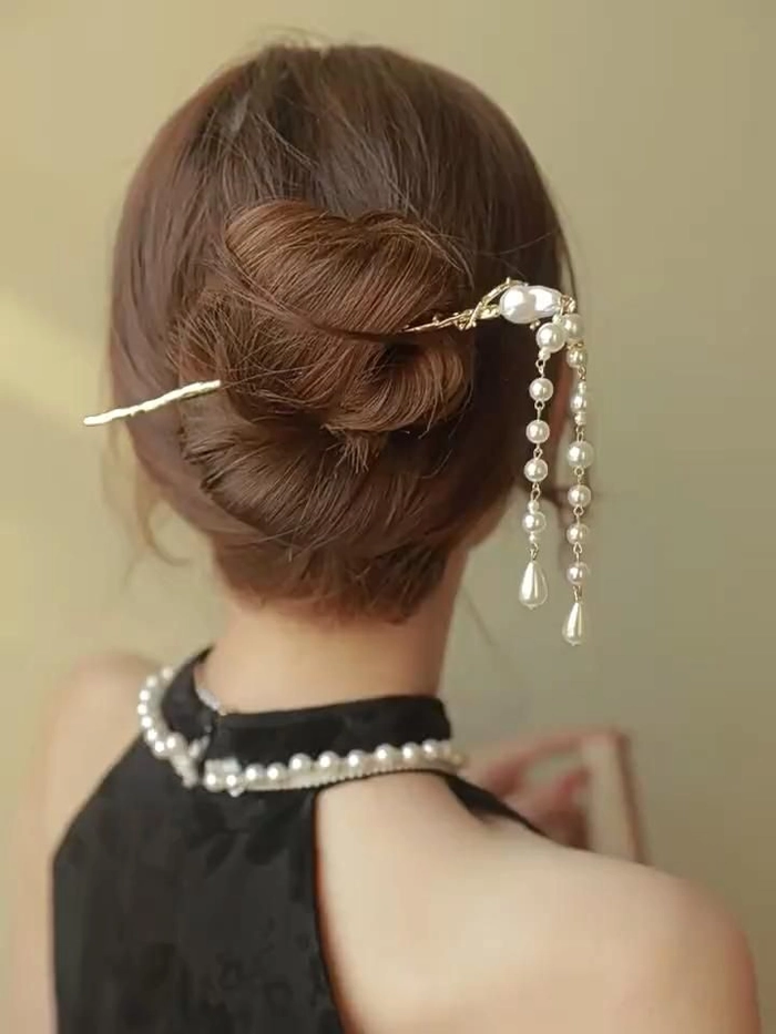 Styling a pearl hair accessory for a festive Christmas dinner party Pearl hair accessory styling for Christmas dinner, elegant updo with white pearls