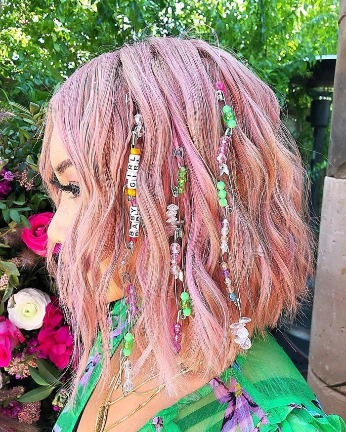 Neon hair chalk in vibrant pink and blue colors on a woman with a braided updo at a rave party