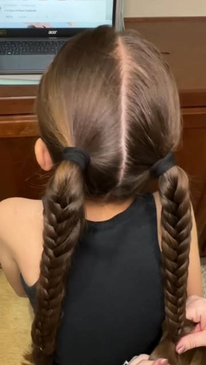 Little girl with festive braided pigtails and holiday bows