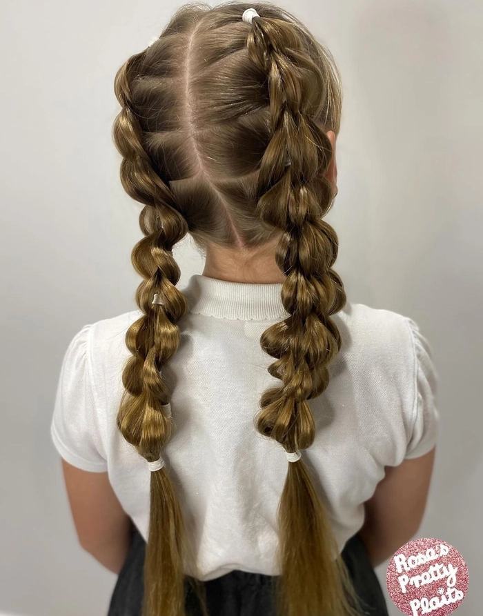 Festive braided pigtails with holiday ribbons on a little girl's hair
