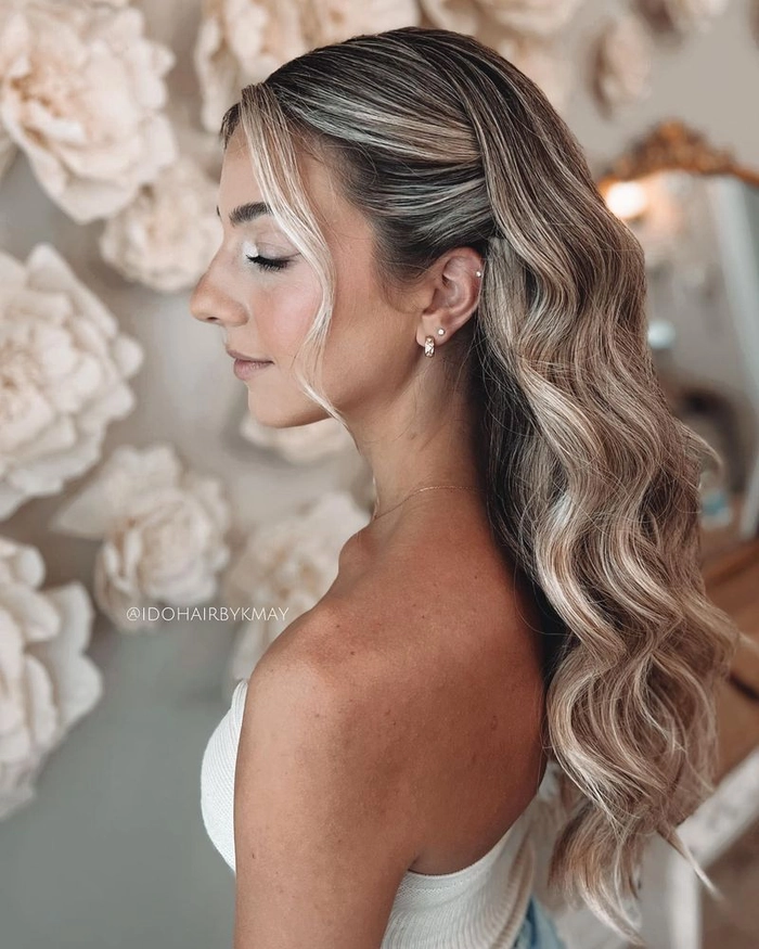 Side swept curls complementing an asymmetrical holiday gown for a festive look