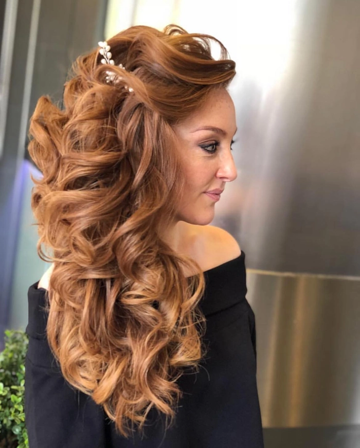 Side-swept curls complementing an asymmetrical gown for a holiday hairstyle