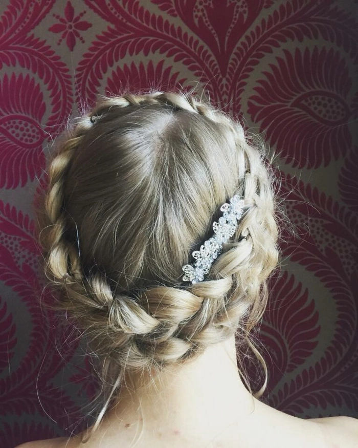 Cozy cabin trip hairstyle inspiration with festive milkmaid braids Woman with milkmaid braids smiling by a cozy Christmas cabin fireplace