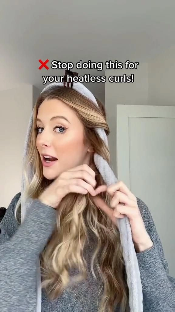 Overnight heatless curl routine results for a festive Christmas morning look Woman smiling with soft, heatless curls while opening a Christmas gift in cozy pajamas