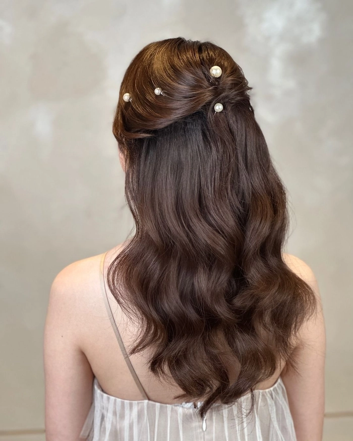 Pearl hair accessory styling ideas for a Christmas dinner hairstyle Woman with pearl hairpins and a festive updo for Christmas dinner
