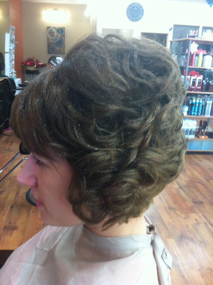 Side swept curls complementing an asymmetrical gown for holiday hairstyles inspiration