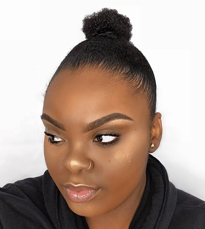 Sleek top knot hairstyle complementing a minimalist holiday outfit with clean lines and simple elegance
