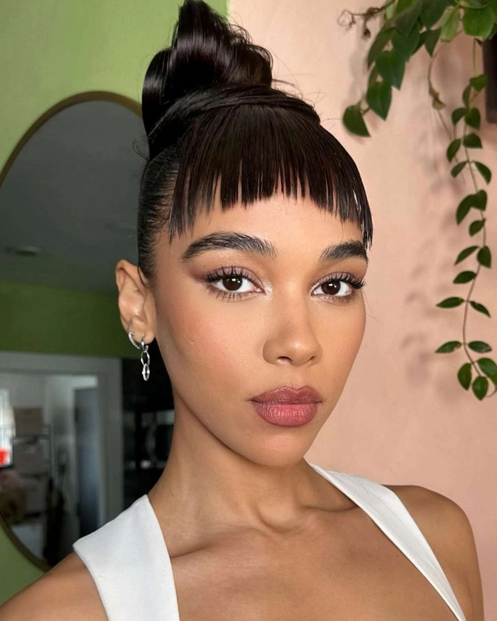 Sleek top knot hairstyle for minimalist holiday outfits