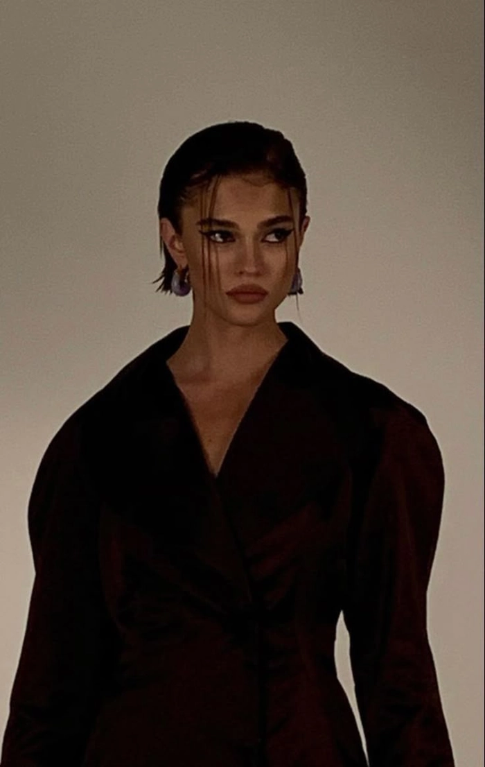 Sleek wet look hair with a dark, glossy finish styled for a villain-inspired holiday aesthetic