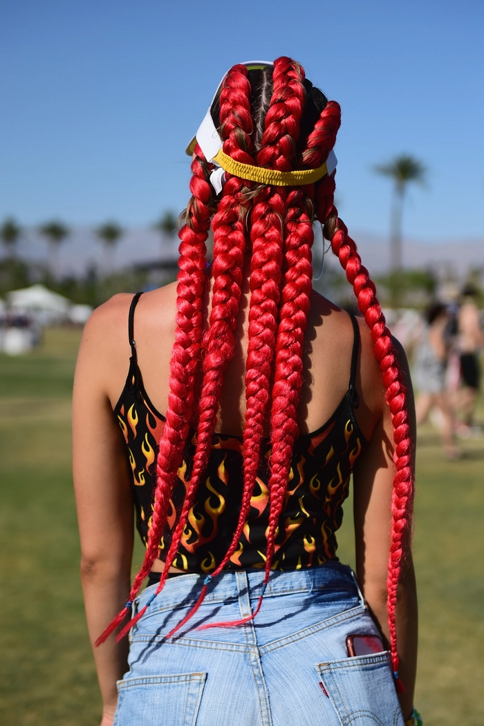 Traditional hair braiding with decorative beads and ribbons for a cultural holiday festival celebration