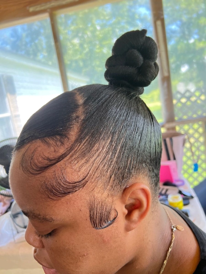 Sleek high top knot perfect for party celebrations High sleek top knot hairstyle for a birthday party