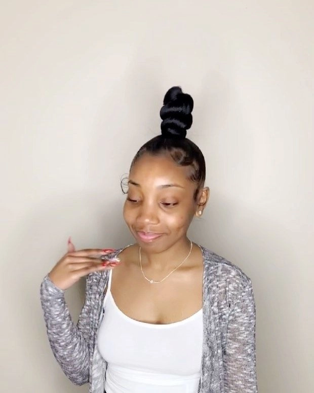 High sleek top knot hairstyle perfect for birthday party festivities Woman with a high sleek top knot hairstyle for a birthday party celebration