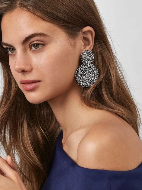Elegant evening updo featuring a twisted bun with sparkling statement earrings