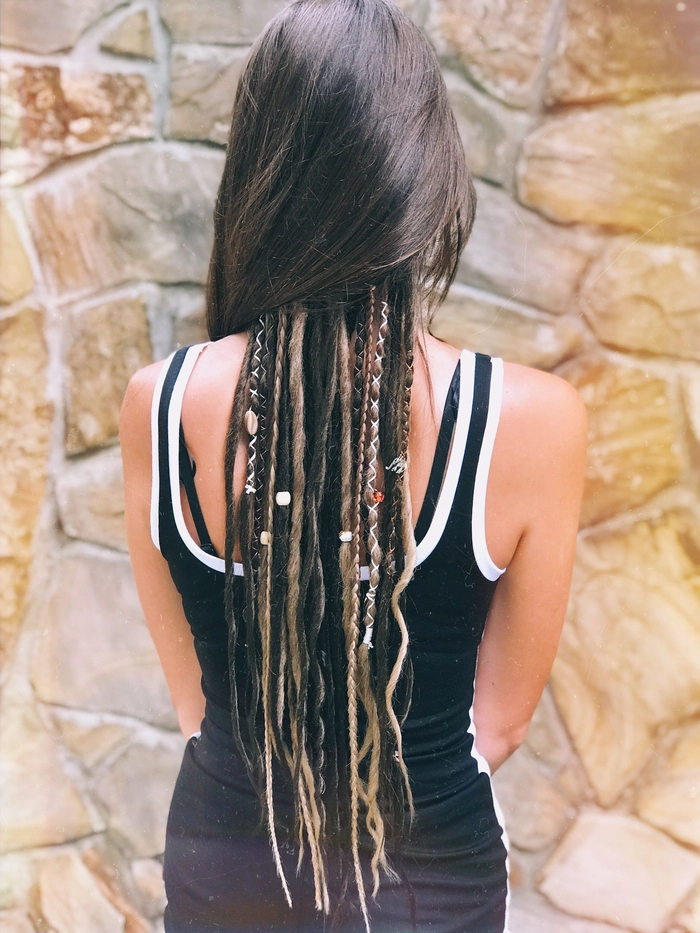 Boho Festival Dreadlock Style with Colorful Beads and Flowers A person with festival-styled dreadlocks and locs decorated with beads and flowers