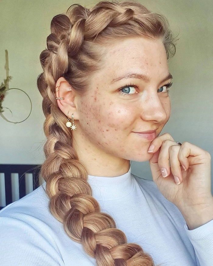 A woman with thick heavy hair styled in elegant gala braids for a party