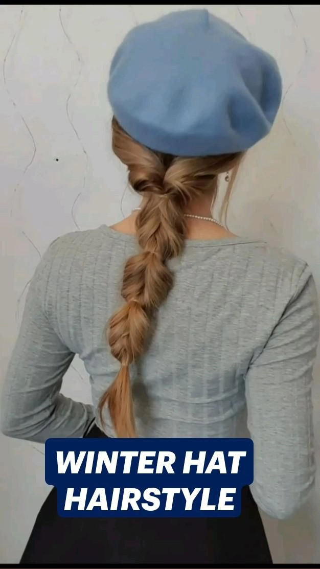 Woman wearing a stylish hat with elegant winter gala hairstyle showing loose curls peeking out
