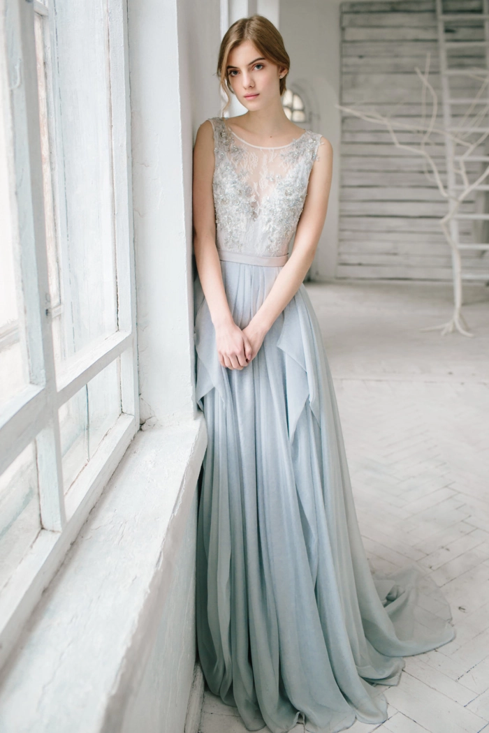 A wedding guest with an elegant updo showcases a heavy beaded formal gown with sophisticated party hairstyle