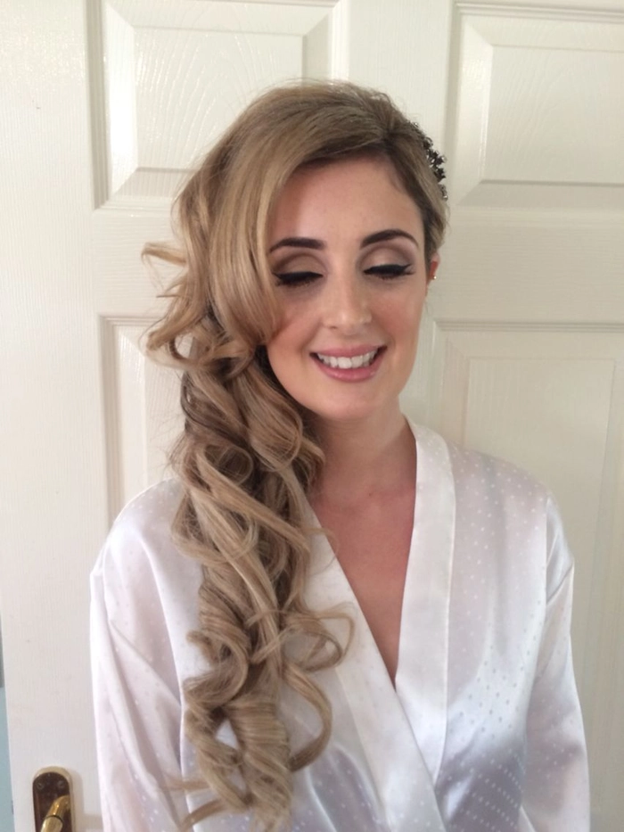Side swept curls styled for New Years Eve with an asymmetric dress
