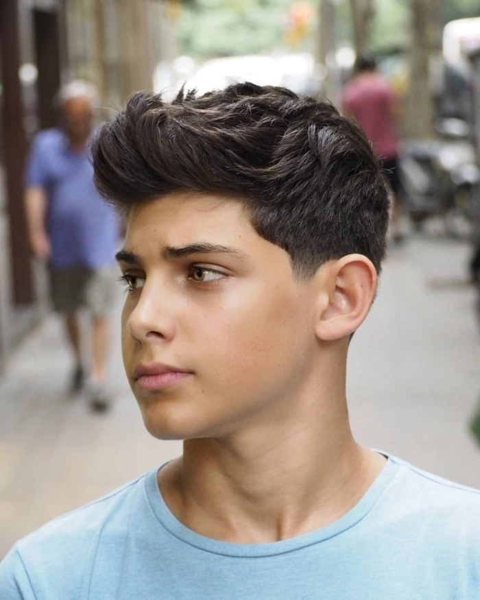 Formal side part hairstyle for teenage boys at a party Teenage boy with a sleek, formal side part hairstyle for a party event