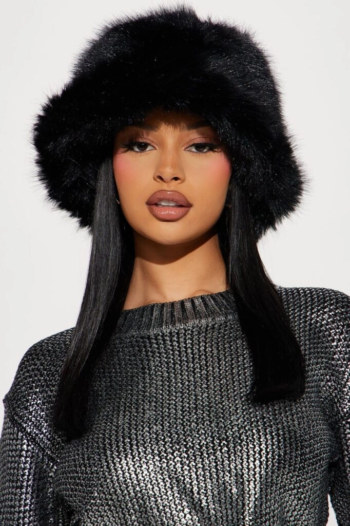 A stylish winter gala look featuring a sparkly hat paired with a sleek low bun.