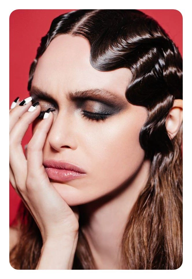 Masquerade ball hairstyle featuring classic finger waves and ornate accessories. Elegant vintage finger waves styled with a shimmering masquerade mask for a glamorous party look.