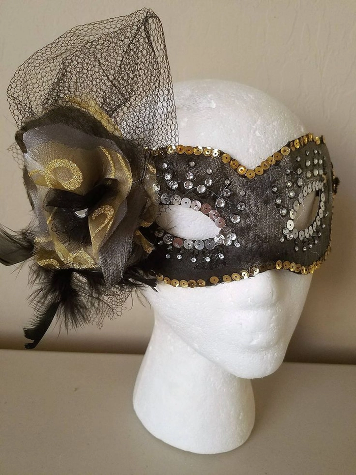 Masquerade ball hairstyle with feather mask coordination Elegant updo hairstyle that complements a feathered masquerade mask for a party look