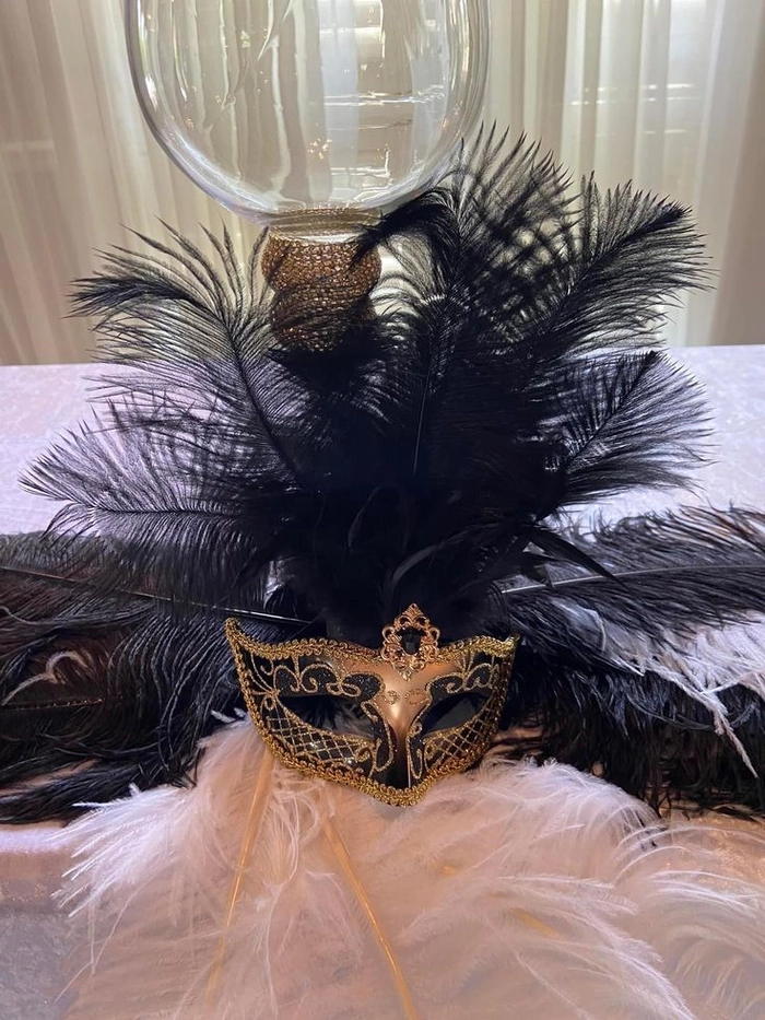 Masquerade hairstyle that perfectly complements a feathered mask Elegant updo with feather mask for masquerade ball