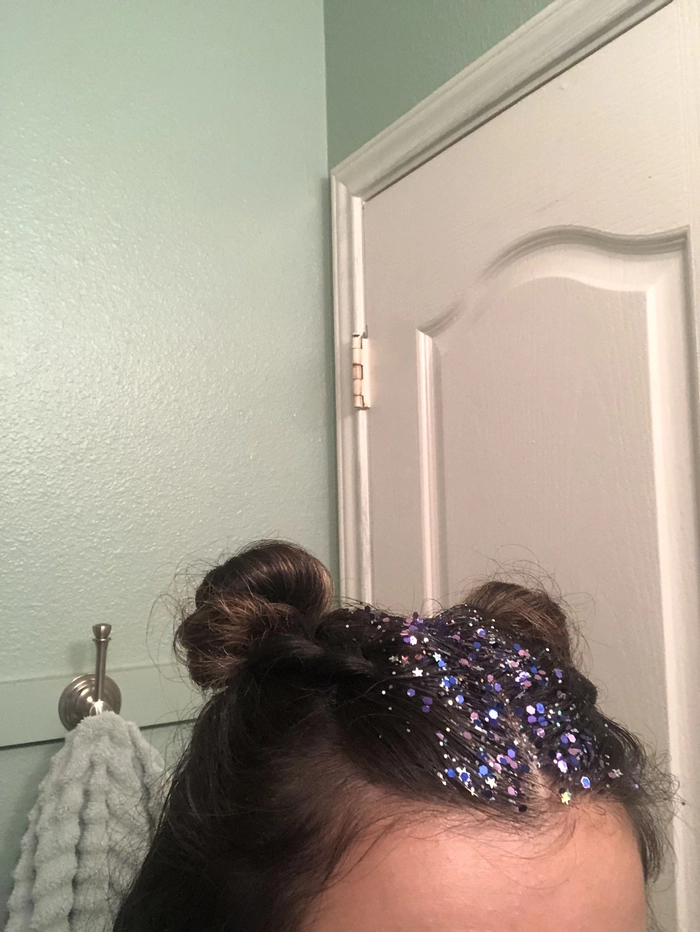 Woman with glitter roots applied to her New Year's Eve hairstyle, party-ready look