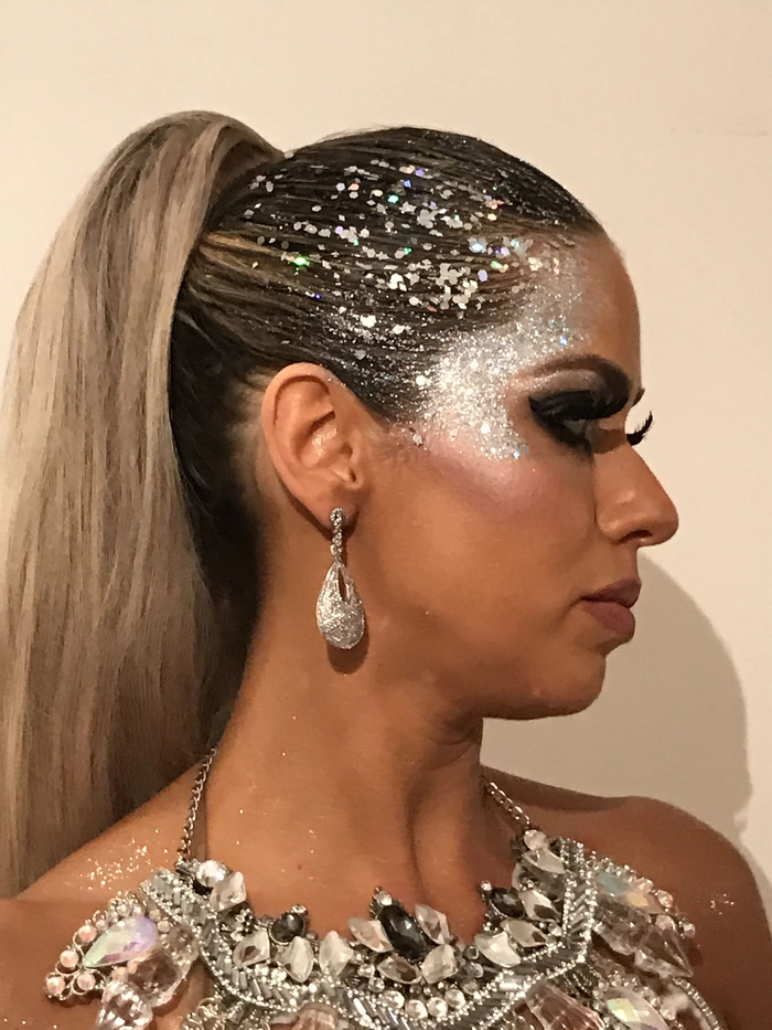 Woman showcasing New Year's Eve hairstyle with glitter root application