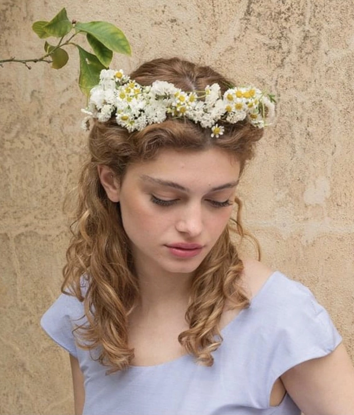Elegant prom look featuring a crown of fresh flowers integrated into flowing curls Prom hairstyle with a fresh flower crown woven into a braided updo