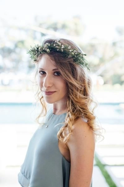 Elegant prom updo accented with a delicate fresh flower crown for a party-ready look. Prom hairstyle featuring a fresh flower crown woven into soft, romantic waves.