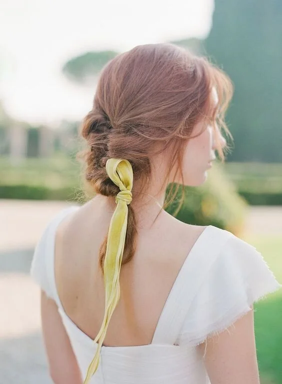 Summer wedding guest braids with delicate floral accents and soft waves Elegant braided updo perfect for a summer outdoor wedding guest