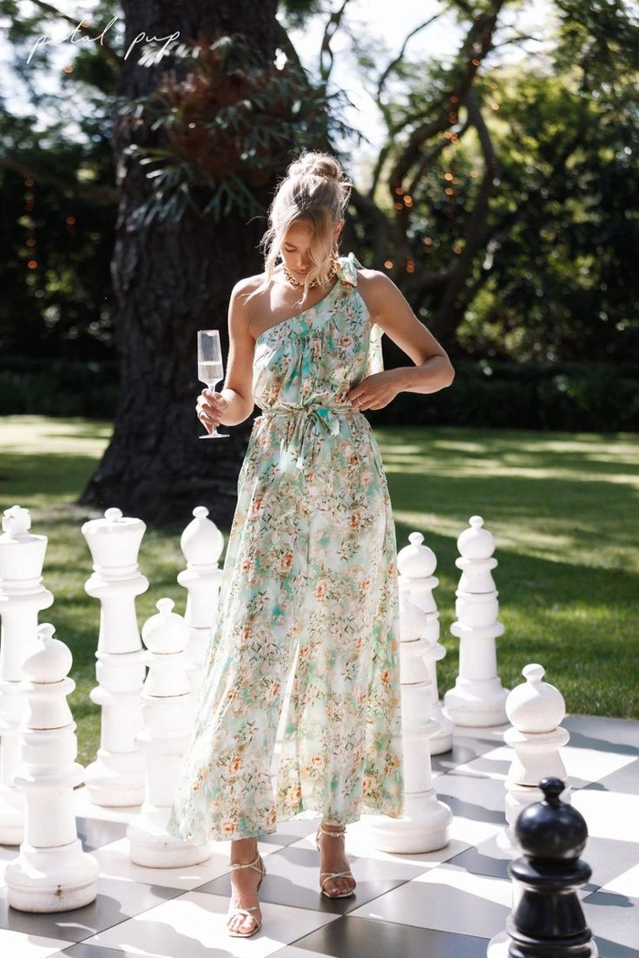 Summer outdoor wedding guest braids hairstyle inspiration A woman wearing a stylish braided updo for a summer outdoor wedding, ideal for party guests.