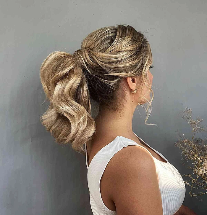 Elegant wedding guest hairstyle for frizzy hair with soft waves and accessories