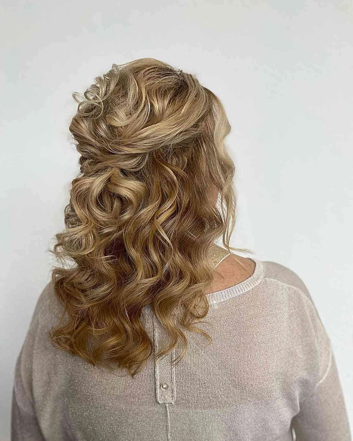 Elegant wedding guest updo for frizzy hair with soft waves and volume