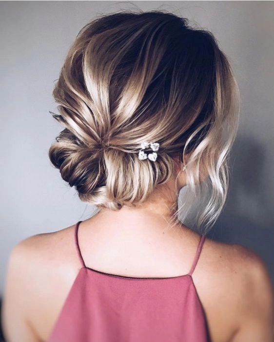 Wedding guest updo featuring soft pastel pink hair with delicate styling Elegant updo hairstyle with pastel pink hair for a wedding guest