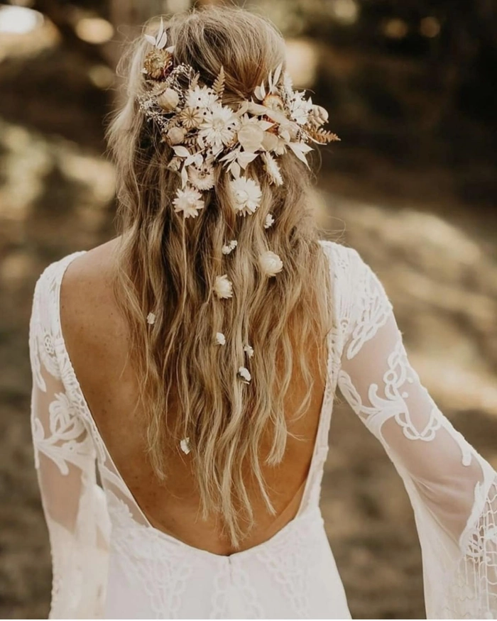 Boho chic prom hairstyle featuring loose waves and floral accents for a natural look