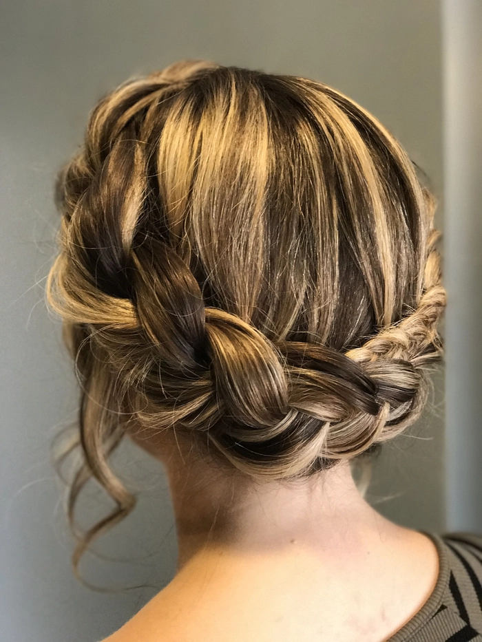 Stunning braided crown updo perfect for prom night glamour Elegant braided crown prom hairstyle with loose curls