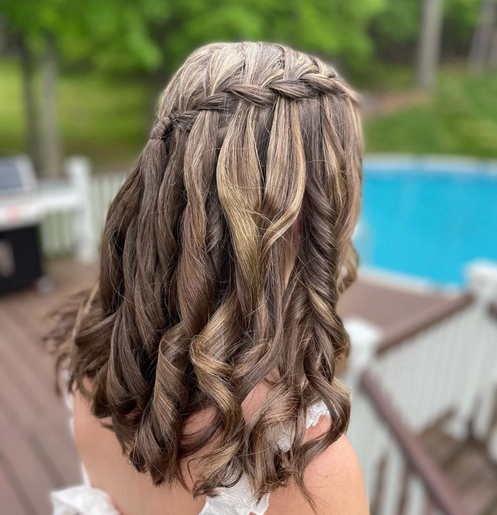 Elegant prom hairstyle featuring a braided mohawk with soft curls