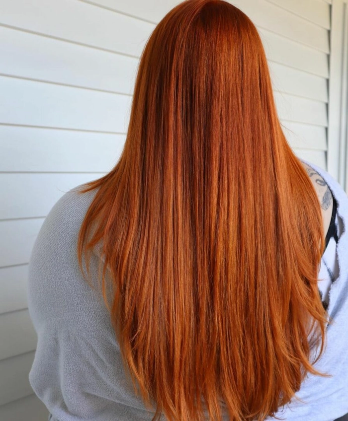 Elegant braided prom hairstyle on copper ginger hair with soft waves