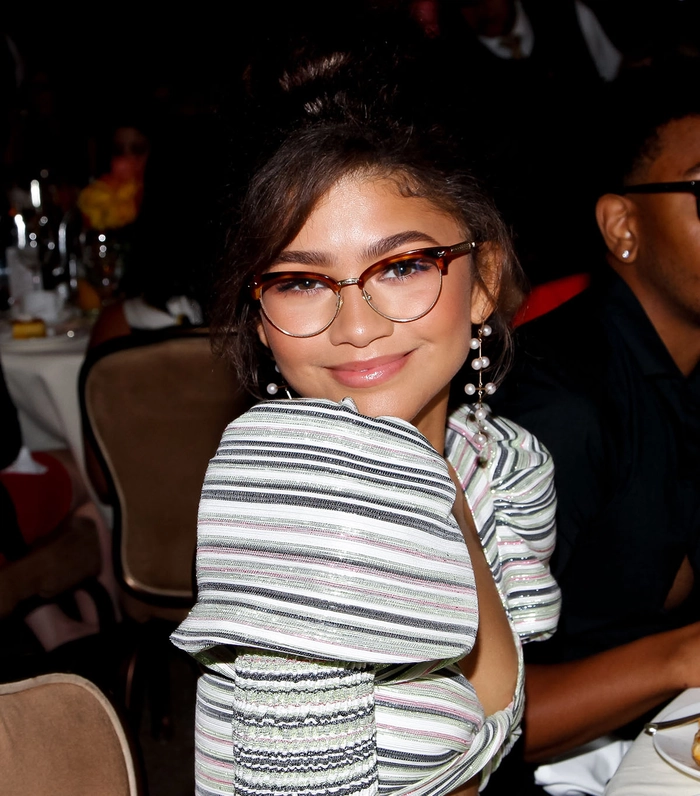 Chic prom hairstyle for girls wearing glasses with sleek side-swept curls
